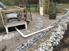 an outdoor hot tub in the middle of a graveled area next to a building