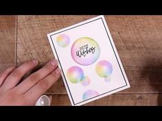 a hand holding a card with watercolor bubbles on it and the words best wishes written in black ink