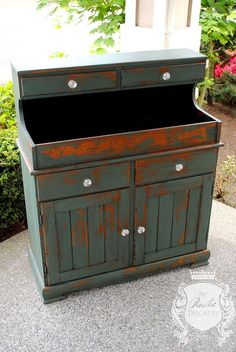 an old dresser is painted green with rust