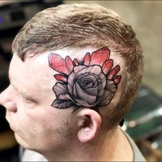 a man with a rose tattoo on his head