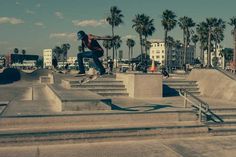 a man riding a skateboard up the side of cement steps at a skate park