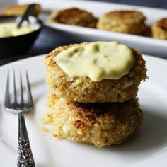 some food is sitting on a white plate with silverware next to it and another dish in the background