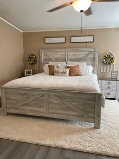 a bedroom with a large bed and white rugs on top of the wooden floor