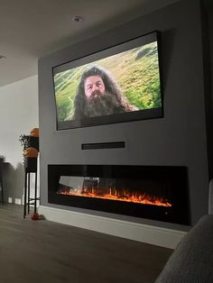 a flat screen tv mounted above a fireplace in a living room