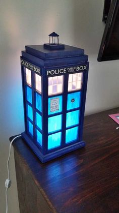 a lamp that is sitting on top of a table in the shape of a police box