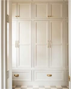 an open closet with white cabinets and checkered flooring