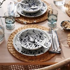 the table is set with dishes and utensils in black dots on white plates