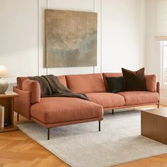 a living room with an orange couch and coffee table