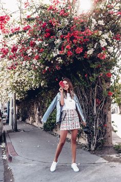 a woman standing in front of a tree with flowers on it and the caption instagram