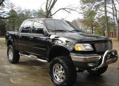 a black pickup truck parked in a driveway