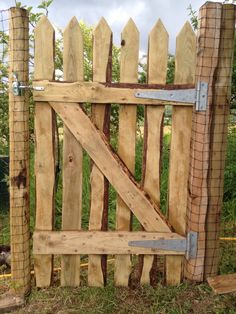 a wooden gate made out of wood with metal bars on the top and bottom part