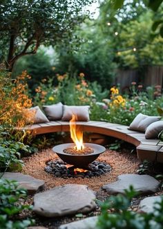 an outdoor fire pit surrounded by plants and rocks