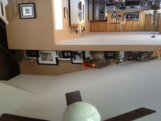 a ceiling fan in a kitchen with pictures on the top shelf and below it is a dining room table