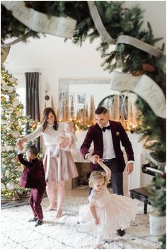 a man and two children are standing in front of a christmas tree with their parents