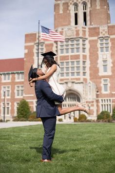 a man carrying a woman on his back in front of a building with an american flag