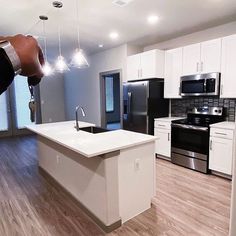 a kitchen with white cabinets and black appliances