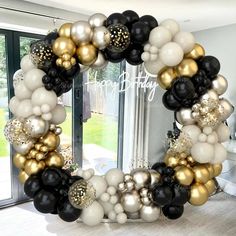 a black, white and gold balloon wreath