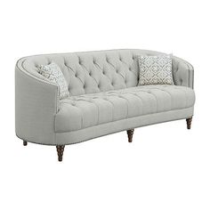 a gray couch with two pillows on top of it and some wood legs in front of it