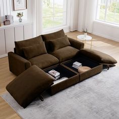 a living room with a sectional couch and coffee table on the floor in front of windows