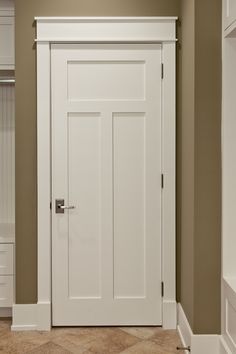 an empty room with a white door and some shelves on the wall, in front of a closet