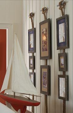 a model sailboat sitting on top of a table next to framed pictures and other items