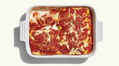 a square casserole dish filled with cheese and pepperoni toppings, on a white surface