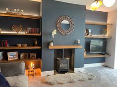 a living room filled with furniture and a flat screen tv mounted on a wall next to a fire place