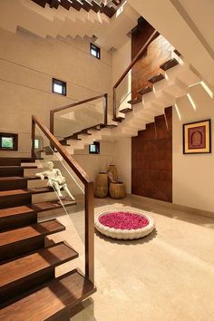 a living room filled with furniture next to a stair case and pink rug on the floor