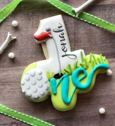 a decorated golf themed cookie on a table with green ribbon and white balls around it