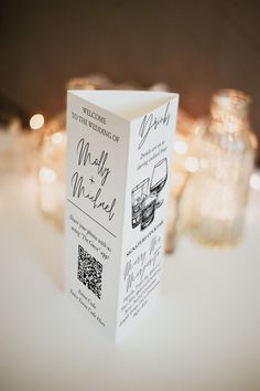 a close up of a box on a table with some candles in the back ground