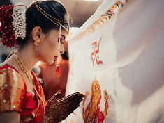 a woman in a red and gold dress holding a white flag with the words india written on it