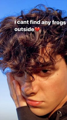 a young man with curly hair has his hand on his face and the words i can't find any frogs outside