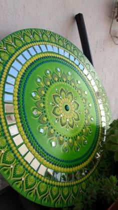 a green plate sitting on top of a table next to a potted plant