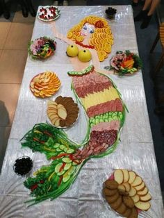 a table topped with lots of food on top of a white table covered in plastic