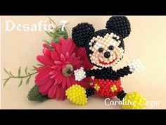 the beaded mickey mouse is holding a flower