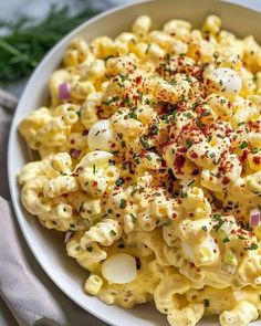 a white bowl filled with macaroni and cheese covered in sprinkles