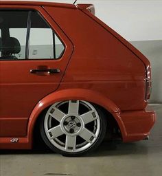 an orange car parked in a garage with its door open