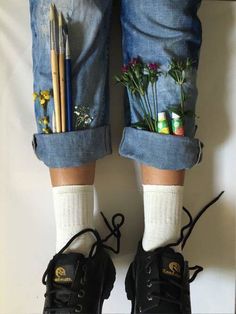 a pair of legs with flowers and pencils in their pockets, tied to the ankles