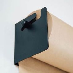 a roll of brown paper with a black clip on it