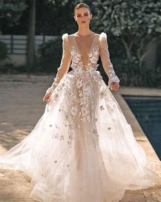 a woman is walking down the runway in a white dress