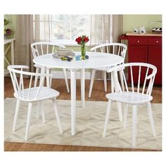 a white table and chairs in a room with a rug on the floor next to it