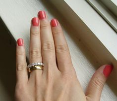 a woman's hand with two different colored nails and a ring on her finger