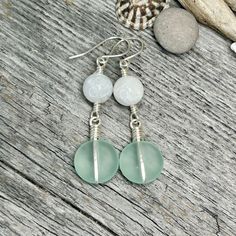 These Alaska Ocean Inspired earrings are sure to bring a lovely beach vibe to your favorite outfit! Made with light aqua sea-glass discs wrapped in silver with moonstone accent beads, all falling from Argentium Silver ear wires. * Earrings Measure: 2 3/8" long x 5/8" wide * Cultured/Frosted Seaglass Discs * Moonstone Beads (10mm) * Argentium Silver Handmade Ear Wires * Earrings are exactly as shown in photos and ready to ship! * US Quarter shown for size reference. * Ships within 1-3 business days via USPS Ground Advantage with Tracking. * Items ship from Alaska, so please allow a little extra time for arrival. * Packaged with Eco-Friendly Paper Bag, Tissue & Bubble wrap for protection. Want to learn more about these earrings, follow me on instagram or facebook! @907northdesigns Hand-wrapped Sea Glass Jewelry For The Beach, Hand Wrapped Sea Glass Jewelry For The Beach, Beach Jewelry With Hand Wrapped Sea Glass, Turquoise Wire Wrapped Earrings For Beach, Beach Sea Glass Earrings With Ear Wire, Beach Earrings With Sea Glass And Ear Wire, Beach Earrings With Recycled Glass And Ear Wire, Round Sea Glass Jewelry For Beach, Round Sea Glass Beach Jewelry