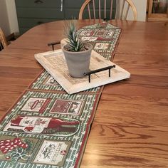 a wooden table topped with a potted plant on top of a placemat next to a green chair