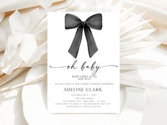 a baby shower card with a black bow on it