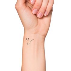 a woman's arm with a small bird tattoo on the left side of her wrist