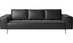 a black leather couch sitting on top of a white floor