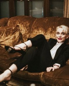 a woman sitting on top of a brown couch