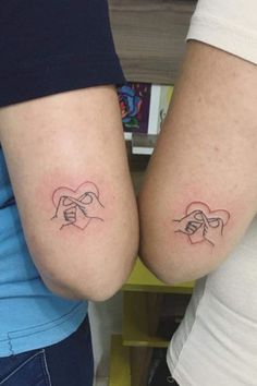 two people with matching tattoos on their arms