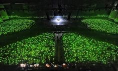 an aerial view of a concert venue with green lights on the floor and in the center